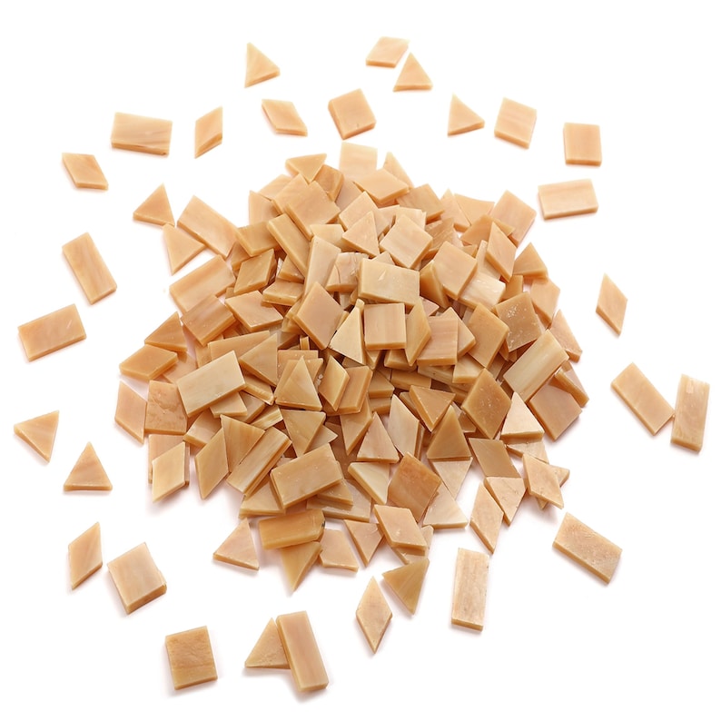 May include: A pile of small, light brown, rectangular and triangular ceramic tiles.