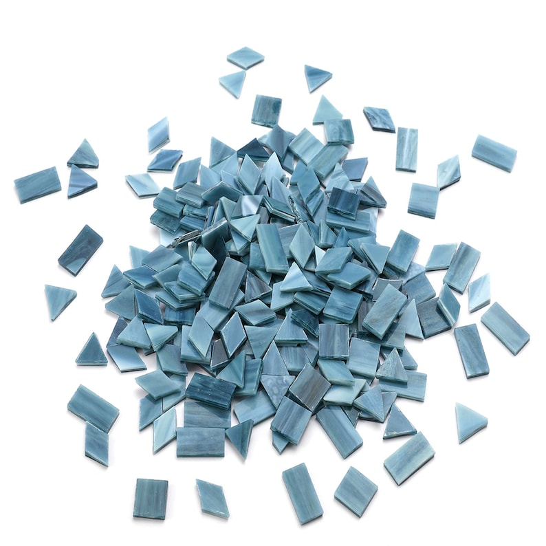 May include: A pile of blue glass mosaic tiles in various shapes, including squares and triangles.