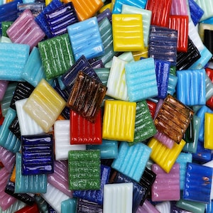 May include: A collection of colorful, square mosaic tiles with various patterns and textures. The tiles are made of glass and have a glossy finish.
