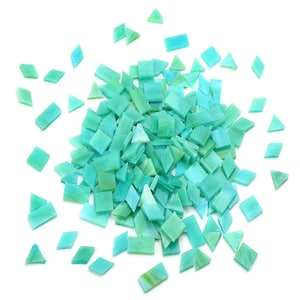 May include: A large pile of turquoise blue glass mosaic tiles in various shapes, including squares and triangles, scattered on a white background.