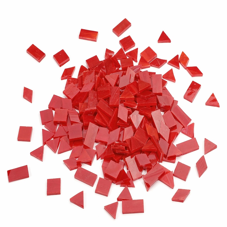May include: A large pile of red glass mosaic tiles in various shapes, including squares and triangles. The tiles are scattered on a white background.
