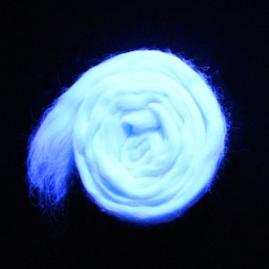 May include: A close-up of a bright blue, fluffy, rolled up ball of fiber. The fiber is likely wool or a similar material.