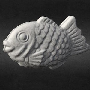May include: A white ceramic fish-shaped mold with a detailed textured surface. The mold is designed to create a traditional Japanese confectionery.