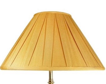 May include: A pleated lampshade in a light gold color. The shade is made of fabric and has a conical shape.
