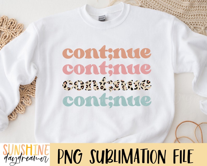 May include: White sweatshirt with the text "continue" repeated four times in different colors. The second "continue" is pink, the third is brown with a leopard print, and the fourth is light blue.