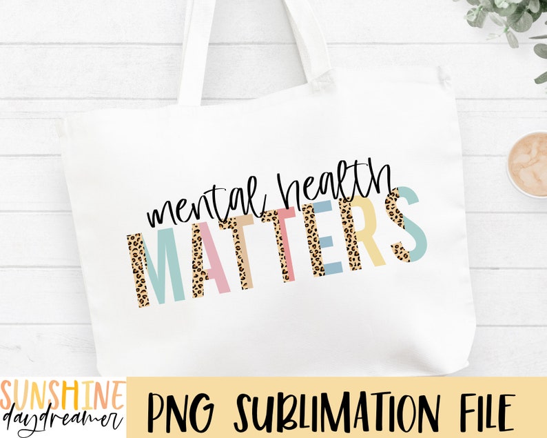 May include: A white tote bag with the text "mental health matters" in black script. The word "matters" is in colorful letters with a leopard print pattern.