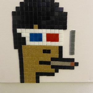 May include: A pixel art mosaic of a person wearing 3D glasses and smoking a cigarette. The person has black hair, a gold-colored face, and a black cigarette.