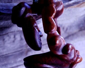 Hand-Carved Lentiscus Wood Pendant: face looking through a spiral window