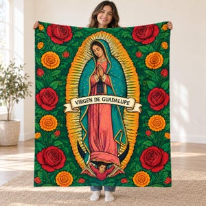 May include: A rectangular throw blanket featuring a central illustration of the Virgin of Guadalupe in a teal cloak and pink robe, surrounded by red roses and orange marigolds on a green background, with the text VIRGEN DE GUADALUPE.