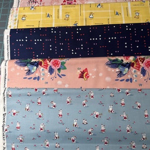 May include: Four different fabric swatches with a whimsical Alice in Wonderland theme. The top swatch is pink with a white castle and characters from the story. The second swatch is yellow with a white grid and characters from the story. The third swatch is dark blue with a white and red pattern of hearts, diamonds, clubs, and spades. The fourth swatch is light blue with a white rabbit pattern.