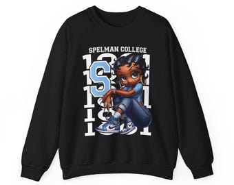 Könnte beinhalten: Schwarzes Sweatshirt mit einer Cartoon-Illustration einer Frau in Jeans und blauem Hemd. Das Sweatshirt hat den Text "Spelman College" und die Zahl "1981" in Weiß und ein hellblaues "S".