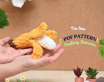 May include: A crocheted banana with a peel that can be pulled back to reveal the white inside. The banana is held in a person's hands. The text "No Sew PDF PATTERN Peeling Banana" is visible in the image.