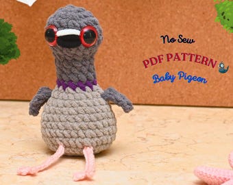 Op de afbeelding: Een handgemaakte grijze gehaakte babyduif met grote ogen met rode randen, een paarse kraag en roze poten. De tekst "No Sew PDF Pattern Baby Pigeon" is zichtbaar op de achtergrond. Een uniek handgemaakt item.