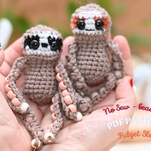 May include: Two crocheted sloth toys with beaded arms and legs. The sloths are brown with white and black faces, and orange accents. The text "No Sew - beaded PDF PATTERN Fidget Sloth" is visible.
