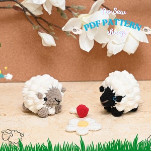 May include: Two crocheted sheep toys, one white with a grey face and one white with a black face, sitting on a tiled surface with a crocheted flower and a red crocheted mushroom. The image includes the text "No Sew PDF PATTERN sheep".