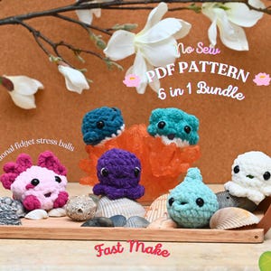 May include: A wooden tray displays six colourful, crocheted stress balls in various sea creature designs. The collection includes an axolotl, octopus, and other aquatic animals. The text "Functional fidget stress balls" and "Fast Make" are visible.