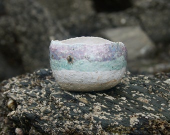 Pottery bowl in pink, blue and white with a sandy texture