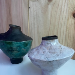 May include: Two ceramic vases, one with a green and black glaze and the other with a white crackle glaze.