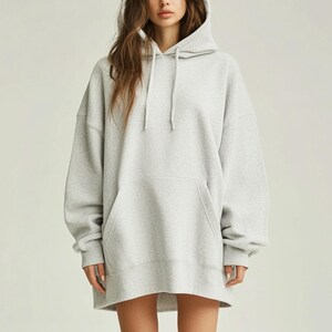 May include: A gray oversized hoodie with a drawstring hood. The hoodie has a kangaroo pocket and long sleeves.