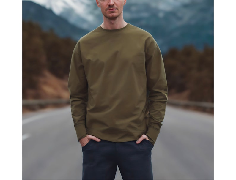 Puede incluir: Una camisa de manga larga de color verde oliva con cuello redondo.