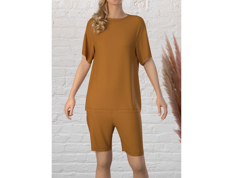 May include: A mustard yellow short-sleeved t-shirt and matching shorts set. The top has a round neckline and the shorts have a relaxed fit.