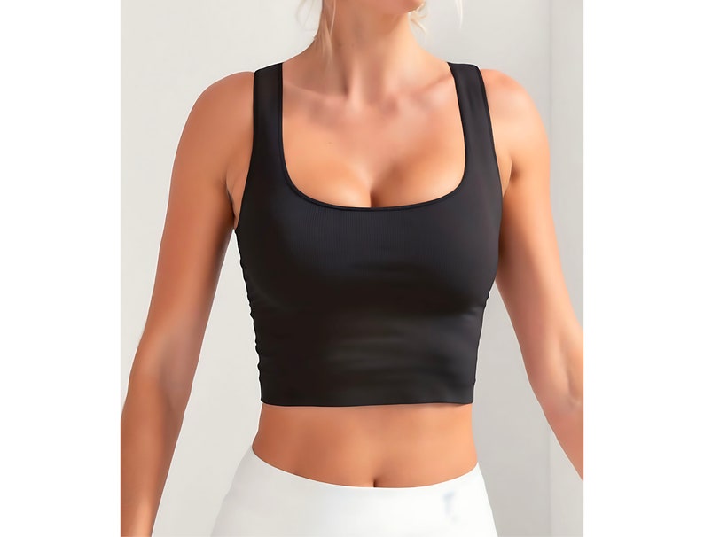 May include: Black cropped tank top with a square neckline. The top is made of a soft, stretchy fabric.
