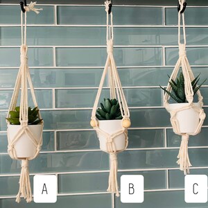 May include: Three macrame plant hangers with white pots and green plants. The hangers are labelled A, B, and C.