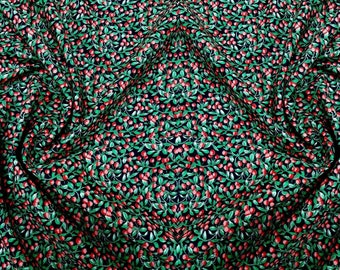 May include: A black fabric with a repeating pattern of green leaves and red berries.