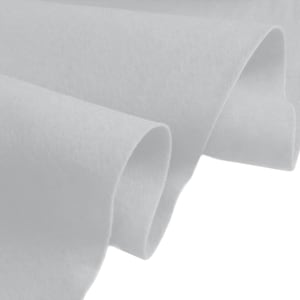 May include: A close-up of a light grey felt fabric. The fabric is folded and the edges are visible. The fabric is soft and smooth.