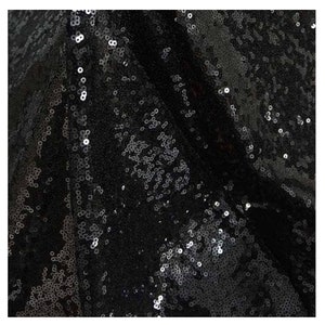 May include: Black fabric with a textured surface covered in small, shiny sequins.