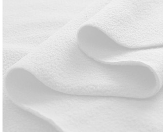 May include: Close-up of a white, soft, and fluffy fabric. The fabric is folded in a way that shows its texture and softness.