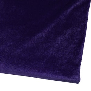 May include: A close-up of a deep purple velvet fabric. The fabric has a soft, plush texture and a rich, luxurious feel.