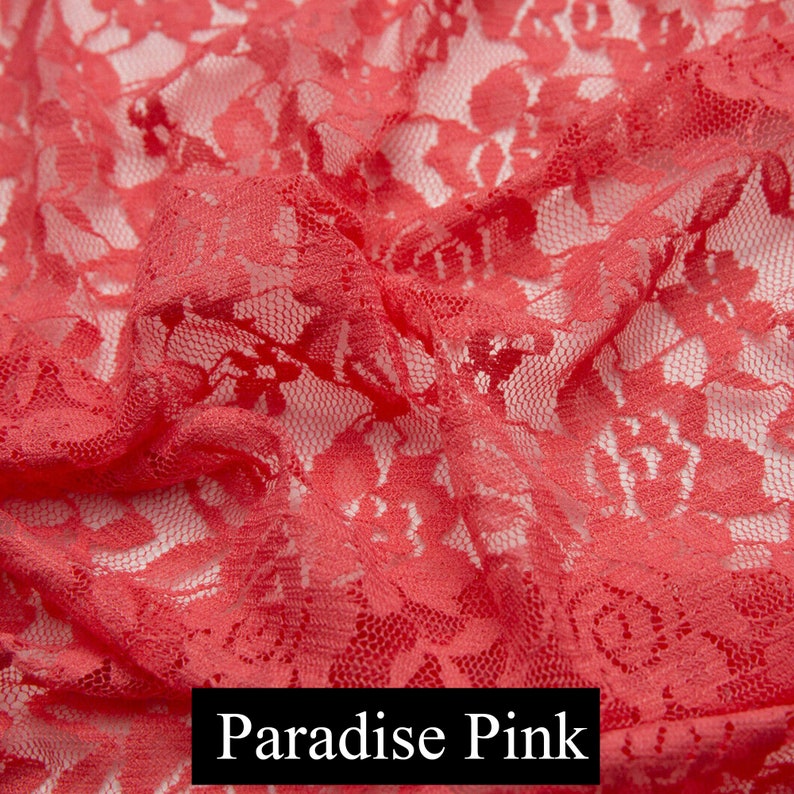 May include: Close-up of a coral pink lace fabric with a delicate floral pattern. The fabric is soft and sheer, with a slightly textured surface. Paradise Pink.