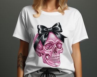 May include: White t-shirt featuring a pink glitter skull with a black bow. The skull design has detailed facial features and is centered on the shirt. The shirt is a casual style, suitable for everyday wear.