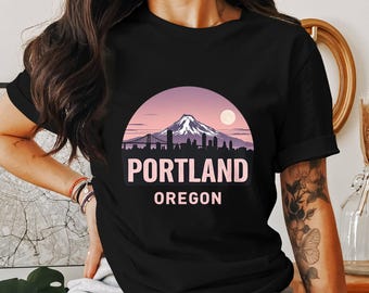 Könnte beinhalten: Schwarzes T-Shirt mit einer pinkfarbenen Grafik einer Bergkette und dem Text "PORTLAND OREGON".