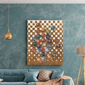 May include: A painting of a checkered board with a pile of colorful marbles in the center. The painting is hanging on a blue wall in a living room setting.