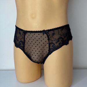 Puede incluir: Ropa interior de encaje negro con un patrón de lunares. La ropa interior tiene un delicado diseño floral y un lazo en la parte delantera.
