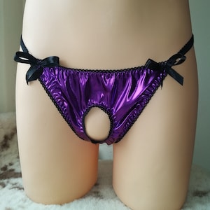 May include: Purple satin underwear with black trim and a cutout detail. The underwear has a bow on each side.