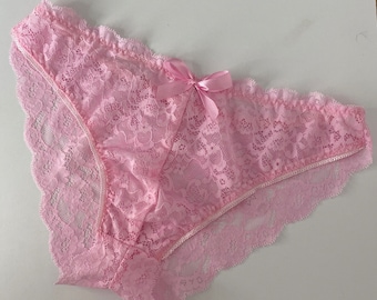 May include: Pink lace underwear with a delicate bow detail.
