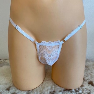 Op de afbeelding: Witte kanten lingerie met verstelbare bandjes. De kant heeft een delicaat bloemenpatroon.
