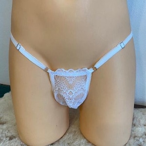 Op de afbeelding: Witte kantenlingerie met delicate bloemenpatronen en verstelbare bandjes.