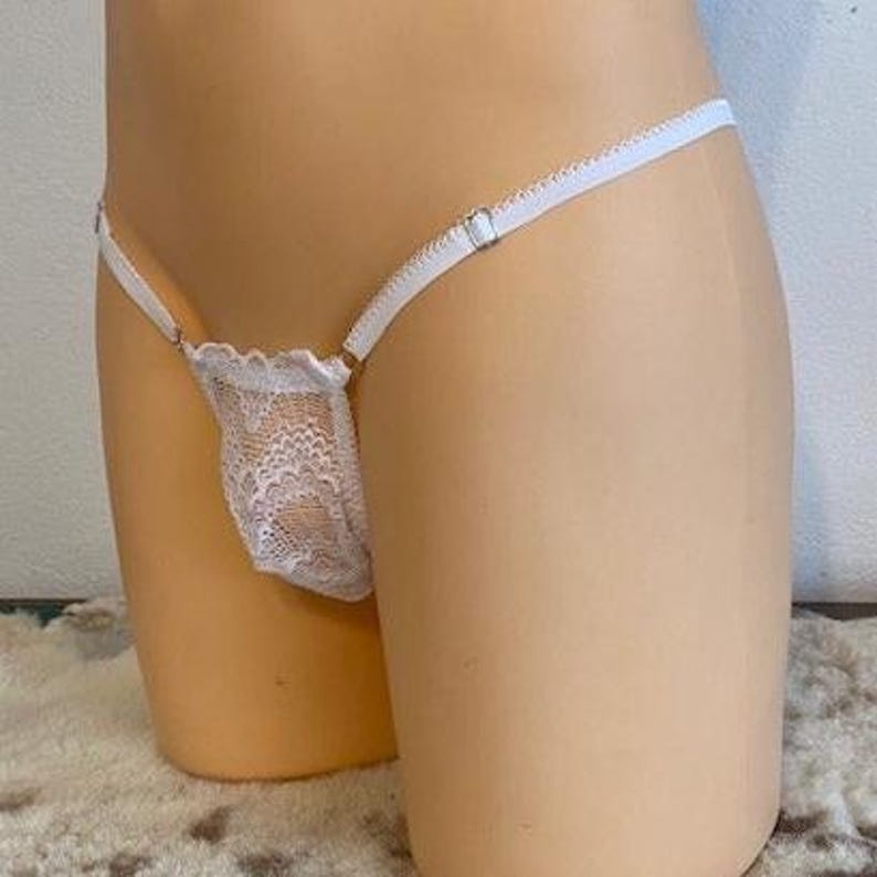 Op de afbeelding: Witte kanten lingerie met delicate bloemenpatronen en verstelbare bandjes.