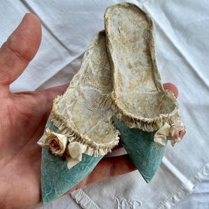 Un paio di mini scarpe di carta blu rosa o crema con rosa pantofola barocca rococò moda Maria Antonietta vintage francese