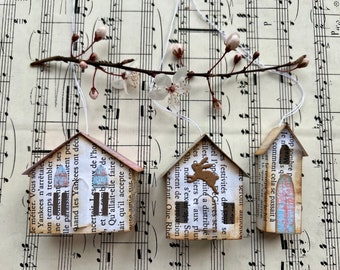 Tres casas decorativas hechas de páginas de libros de papel antiguo con colgantes para ramo de Pascua en un conjunto