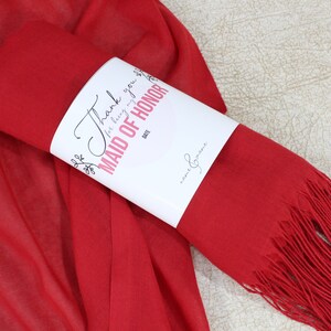 May include: Red pashmina scarf with a white tag that says "Thank you for being my Maid of Honor".