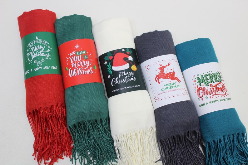 Pode incluir: Cinco diferentes cachec&oacute;is com franjas com tema natalino. Os cachec&oacute;is s&atilde;o vermelhos, verdes, brancos, cinzentos e azuis. Cada cachecol tem uma mensagem de Natal diferente impressa em um r&oacute;tulo.