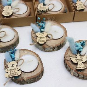 Op de afbeelding: Set van zes houten kaarshouders met theelichtjes, blauwe en witte gedroogde bloemen en gepersonaliseerde houten labels. De labels hebben babythema's en tekst zoals "Baby Shower", "Doop" en "Lorenzo's Baby Shower".