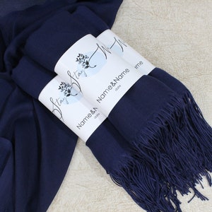May include: Two navy blue pashmina scarves with fringe, wrapped and tied with a white label that says "Stay Strong" and "Name & Name date".