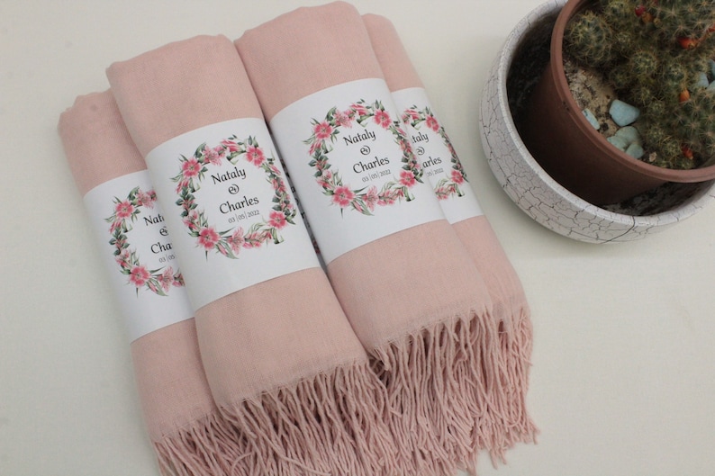 May include: Four pink pashmina shawls with floral designs and the text "Natly & Charles 03.05.2022" printed on the labels.