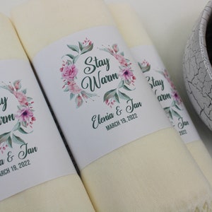 May include: Two cream-colored towels with floral designs and the text "Stay Warm" and "Elenia & Jan March 19, 2022".